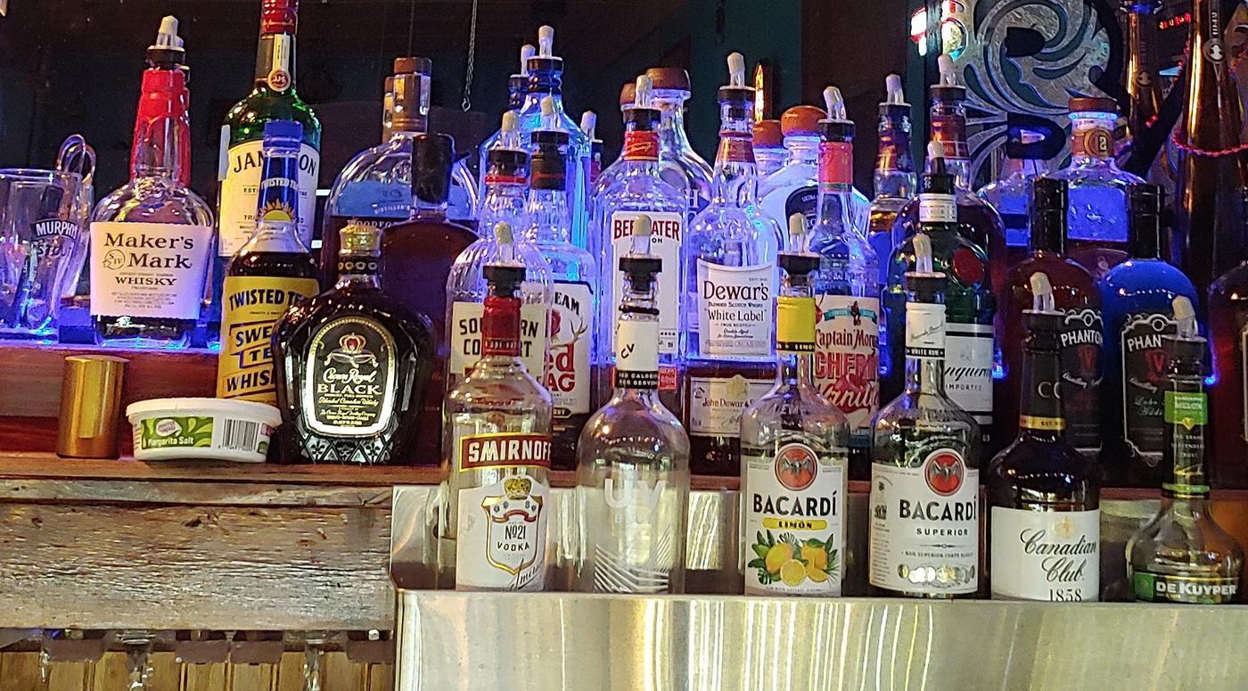 The backbar, bottles lit blue from beneath